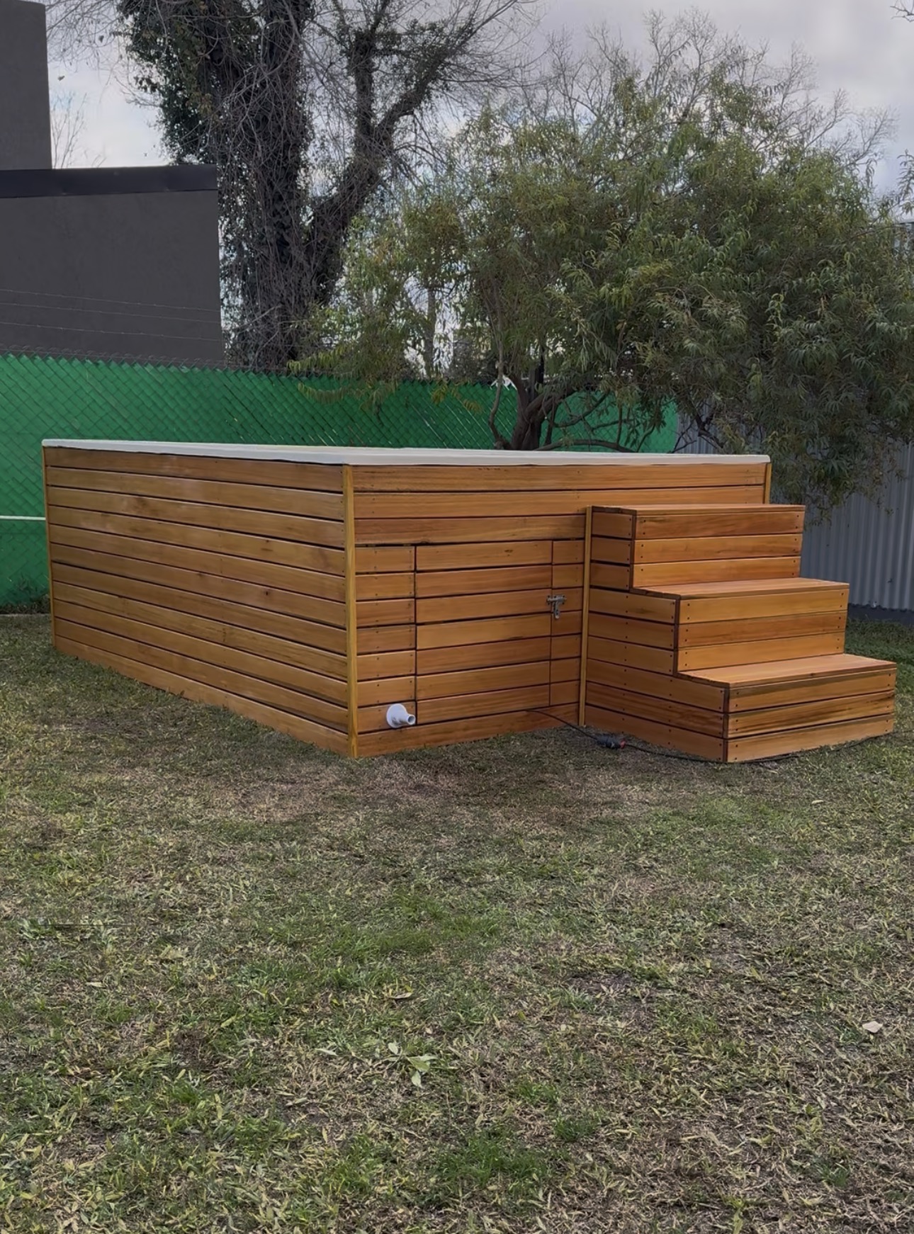 Piscina Oasis 215 instalada con deck y escalera de madera